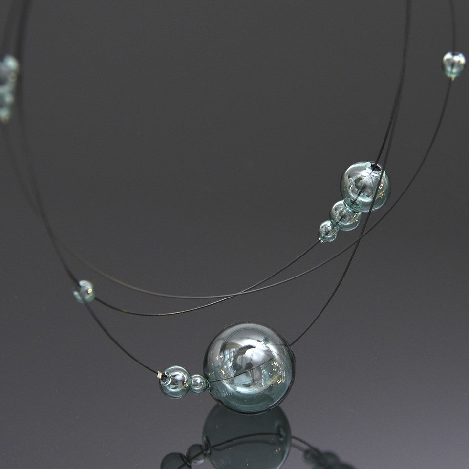 Full view of layered necklace with glass balls.