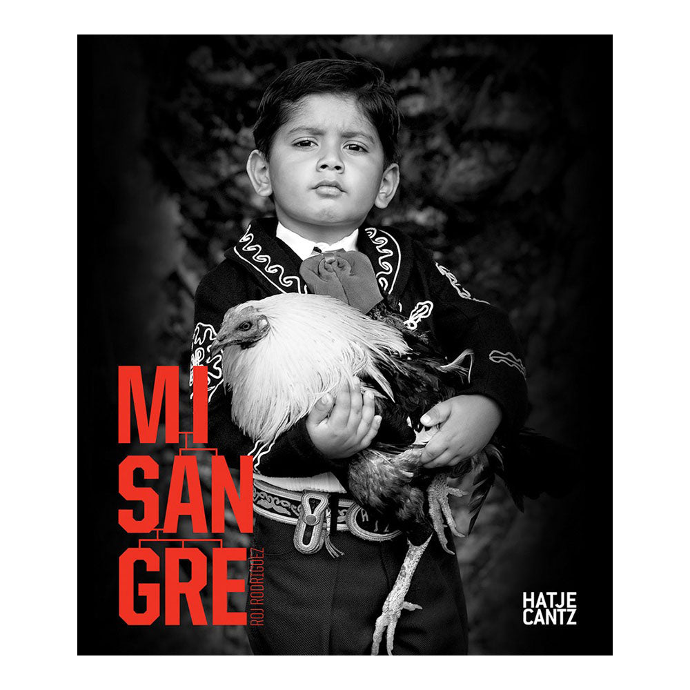 Cover of 'Mi Sangre'. Young boy wearing formal attire holds a living chicken.