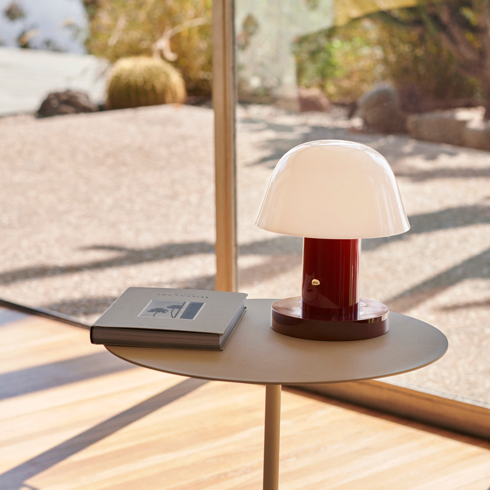 Portable lamp on side table outside.