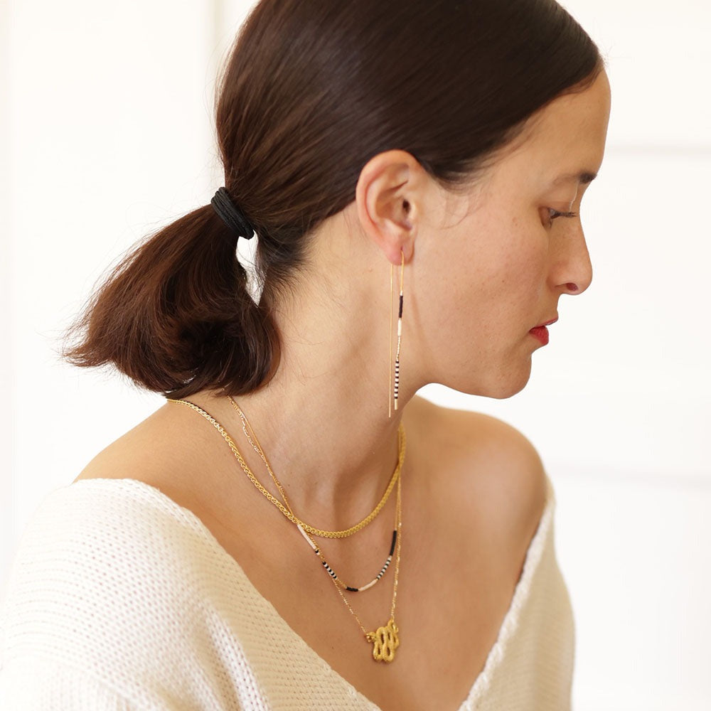 Model wearing necklace with matching threader earrings.