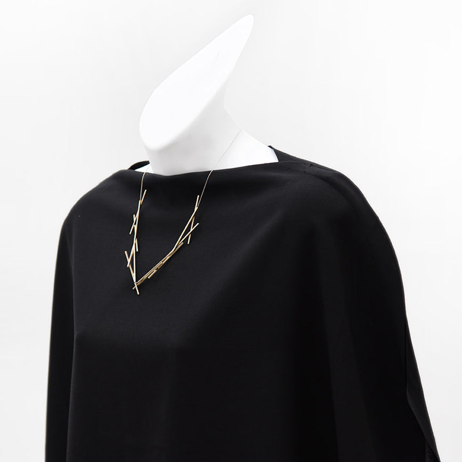 Styled view of gold necklace on black fabric.  