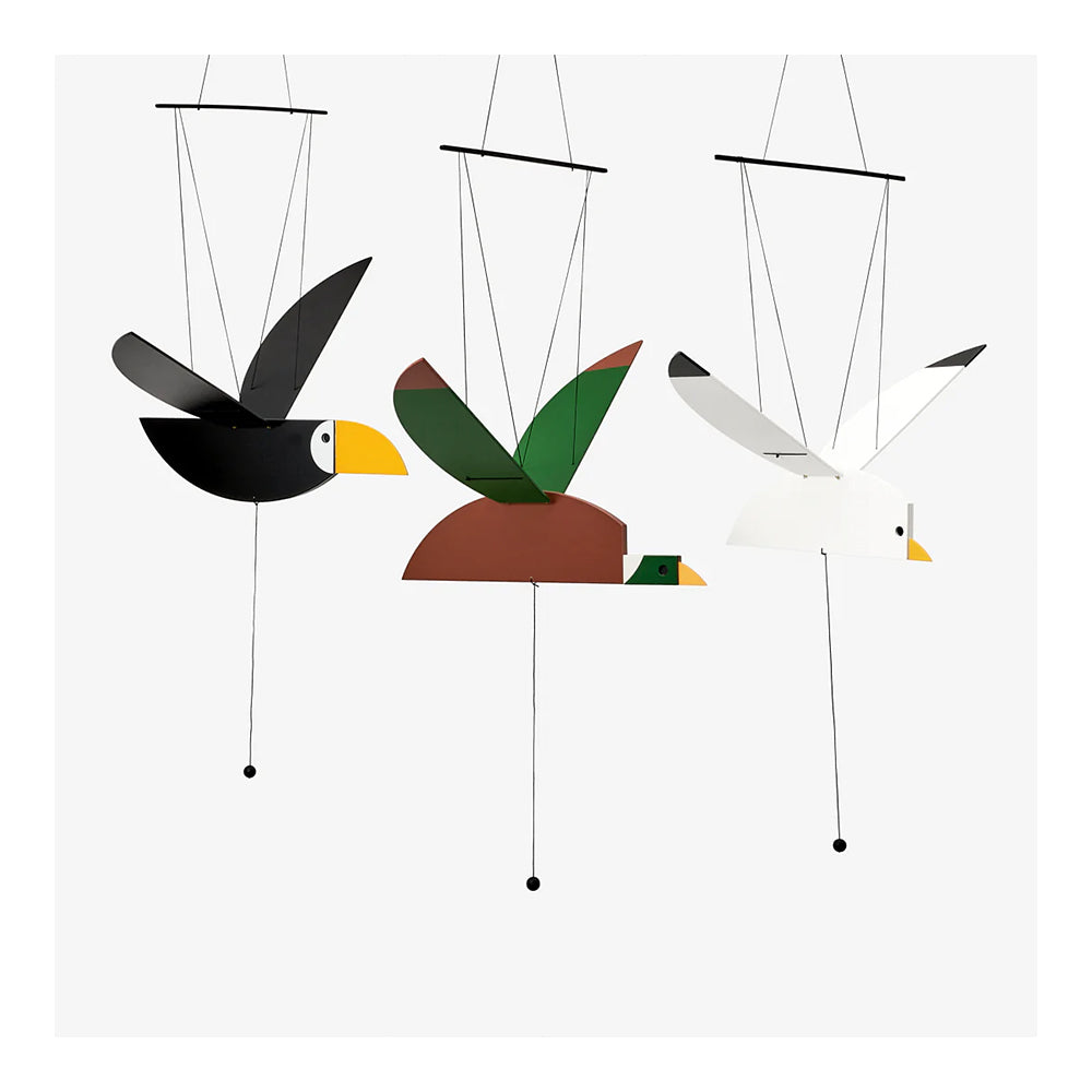 Wooden duck mobile, painted brown and green with white neck accent and yellow beak, hanging from black strings. Alongside seagull and toucan mobiles.