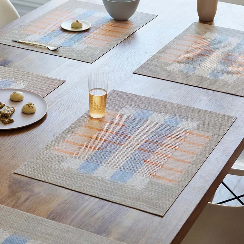 Mesa Opal placemats on a set table. A beverage and pastries around the table.