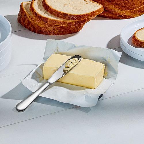 ButterUp Knife cutting into a stick of butter on a table next to bread.