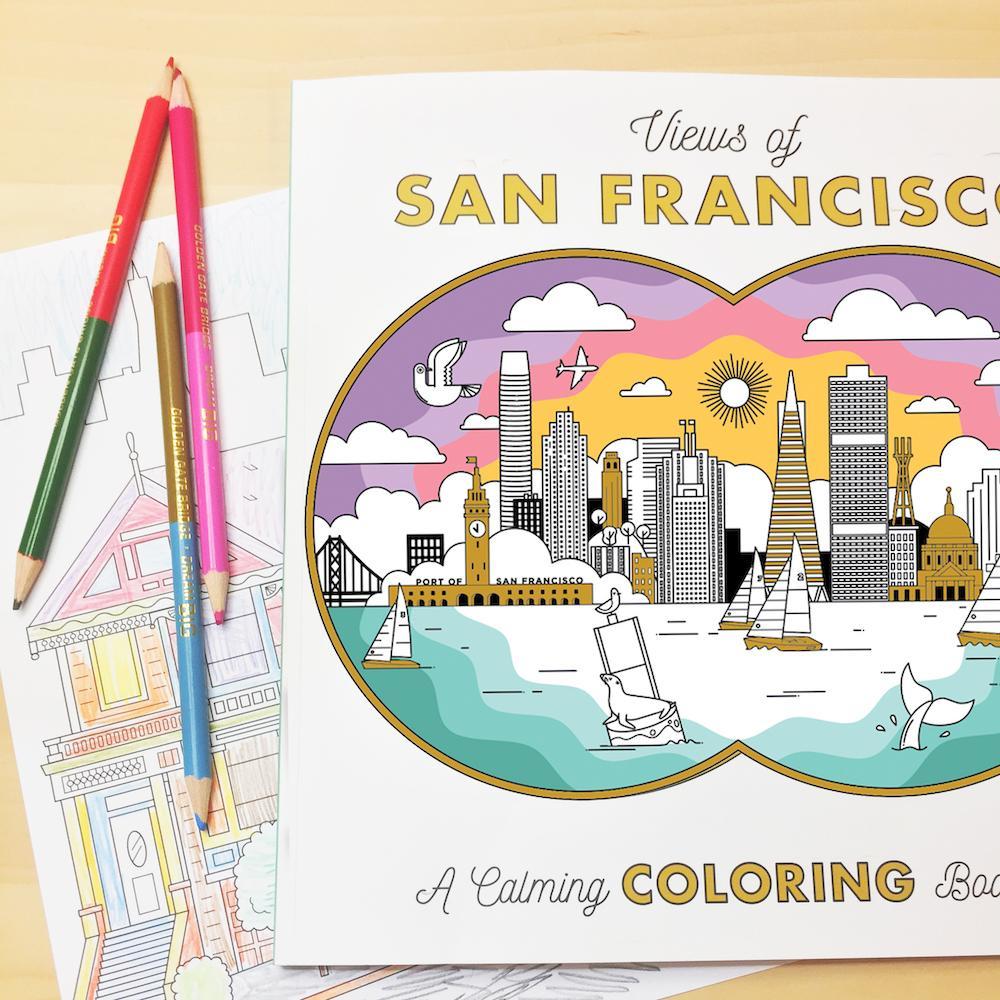 A Views of San Francisco Calming Coloring Book displayed on top of one of its pages and colored pencils.