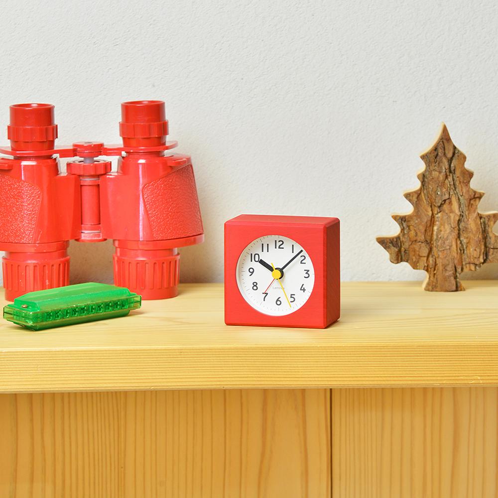 The Farbe Alarm Clock: Red displayed on a shelf.