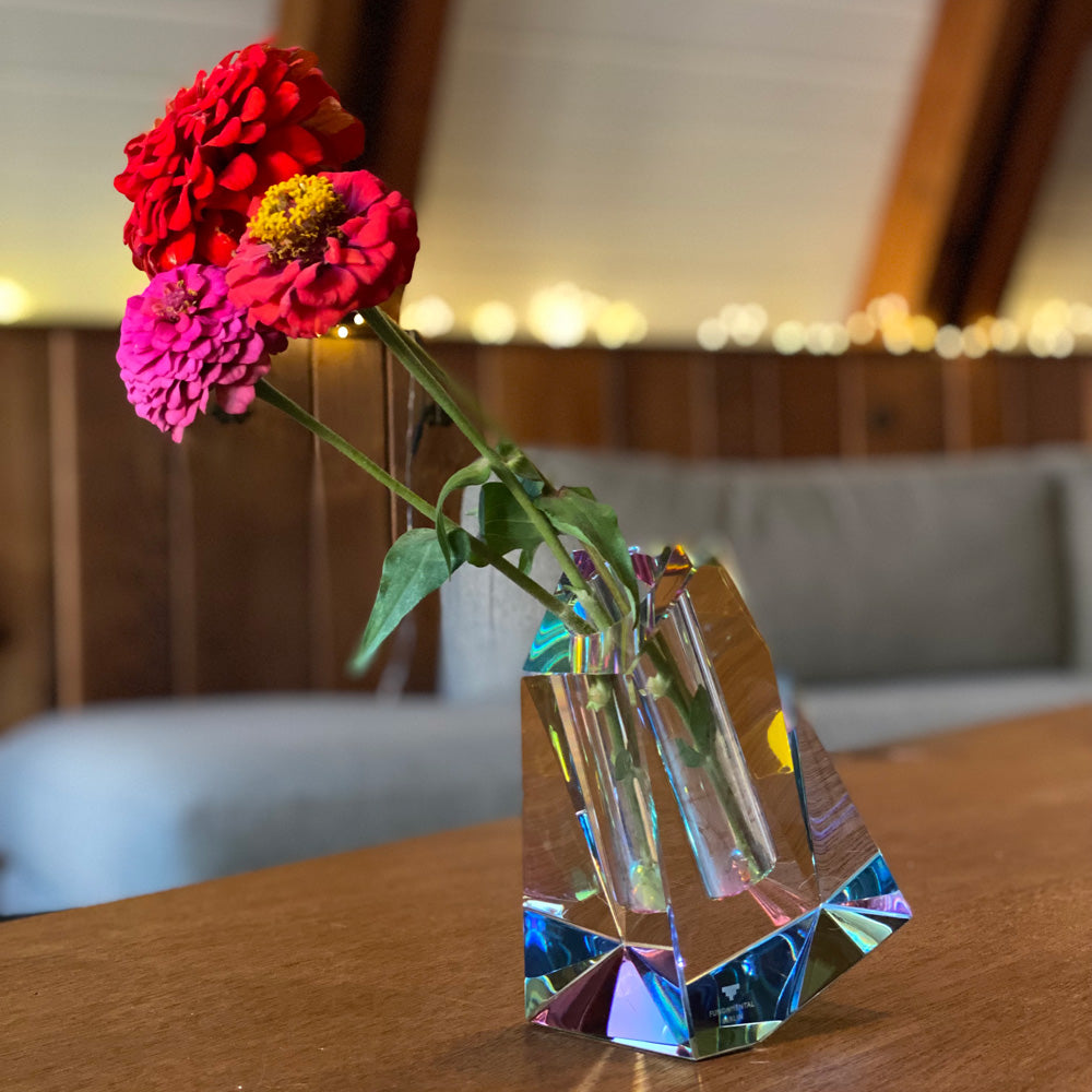 Irregular vase with flowers on table.