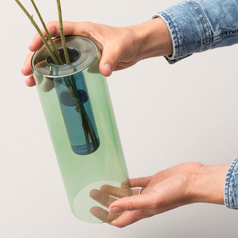 a Reversible Vase: Green + Blue held up with flowers.