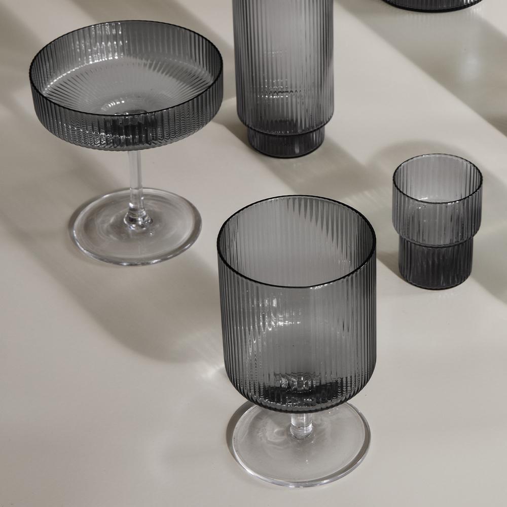 A Ripple Champagne Smoke Glass displayed with other glasses from the collection.