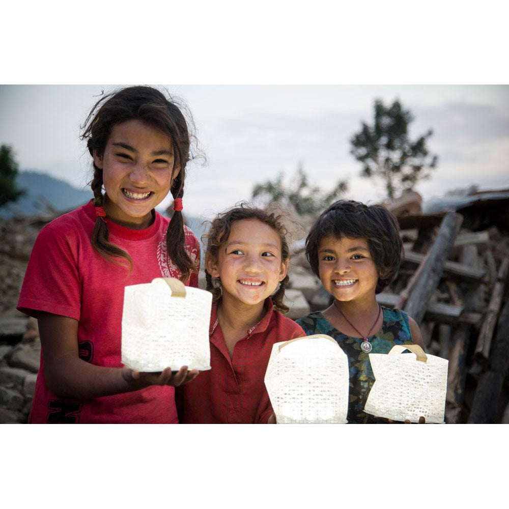 Three children holding lit SolarPuffs.