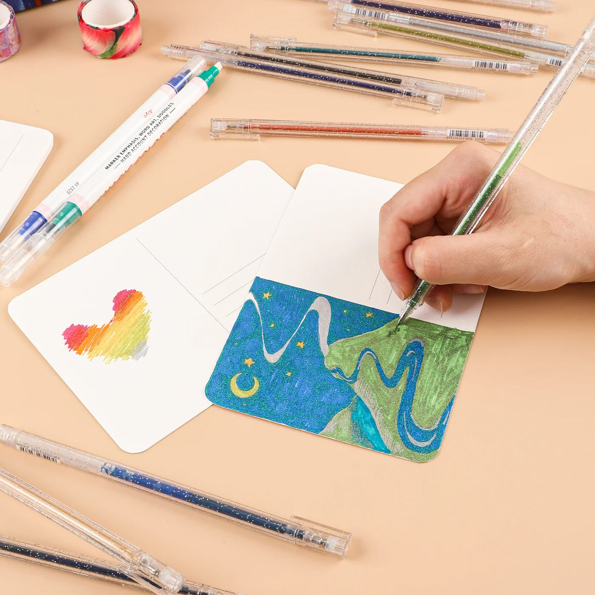 Person coloring a landscape with markers on a beige surface with art supplies.