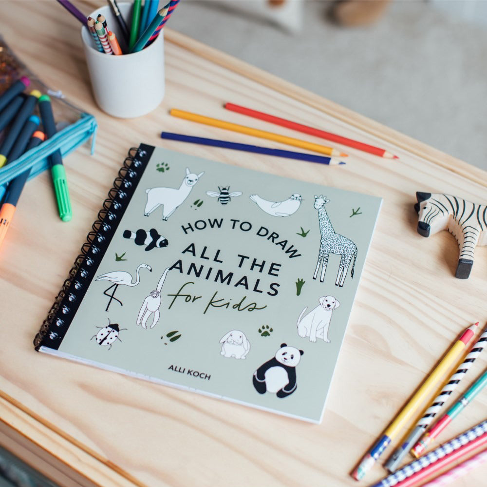 Book titled 'How to Draw All the Animals for Kids' with illustrations of various animals.
