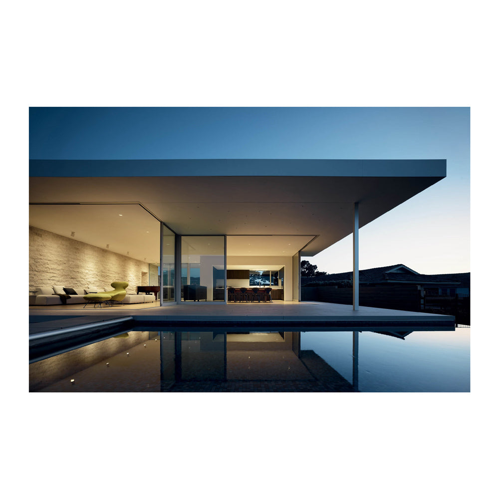 Interior page featuring an image of a modern house with a pool at dusk. 