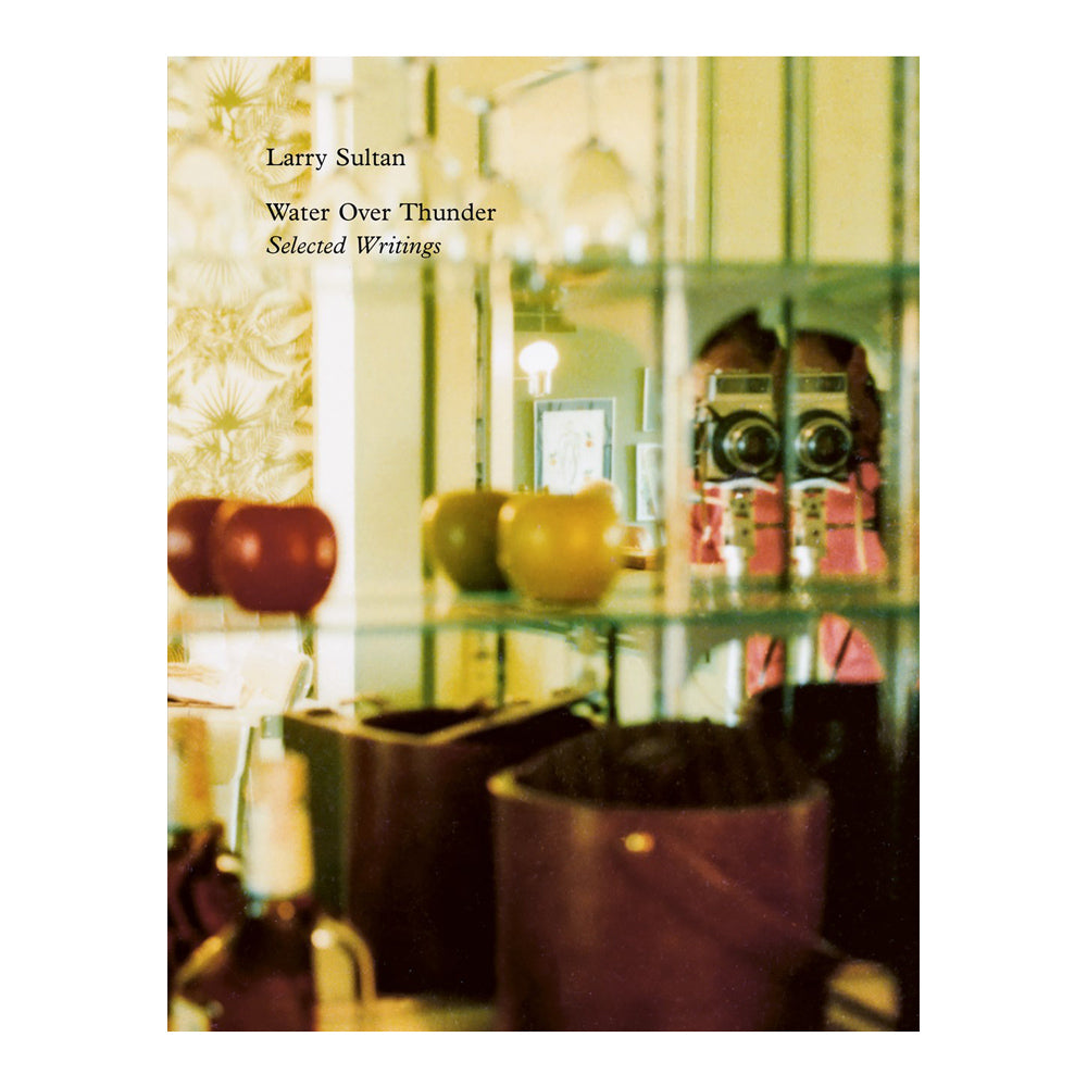 Book cover with a glass shelf displaying various items and text 'Larry Sultan Water Over Thunder Selected Writings'.