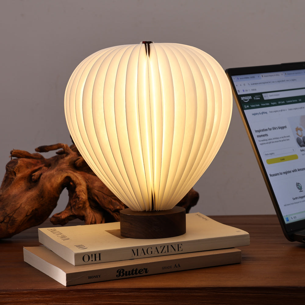 Decorative lamp on a stack of books with a blurred laptop in the background
