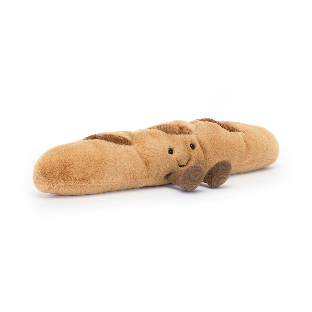 A plush shaped like a baguette of bread, featuring a soft tan body, darker brown crust details, and a small smiling face with brown feet, shown on a clean white background.