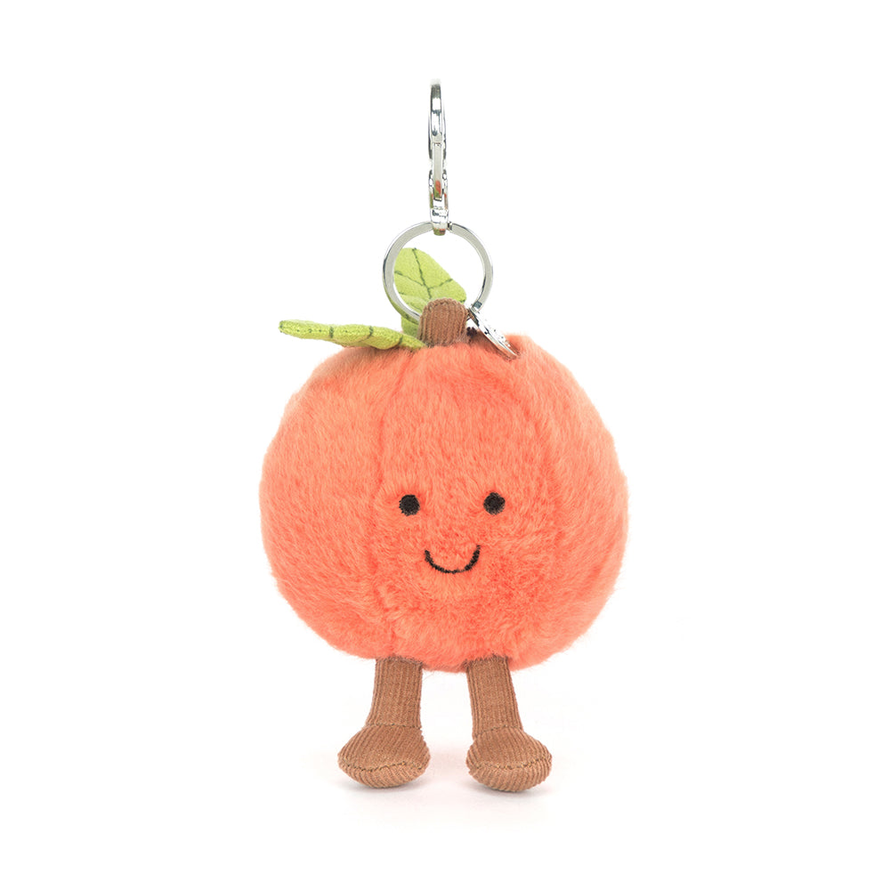 Plush peach character keychain with a happy face on a white background