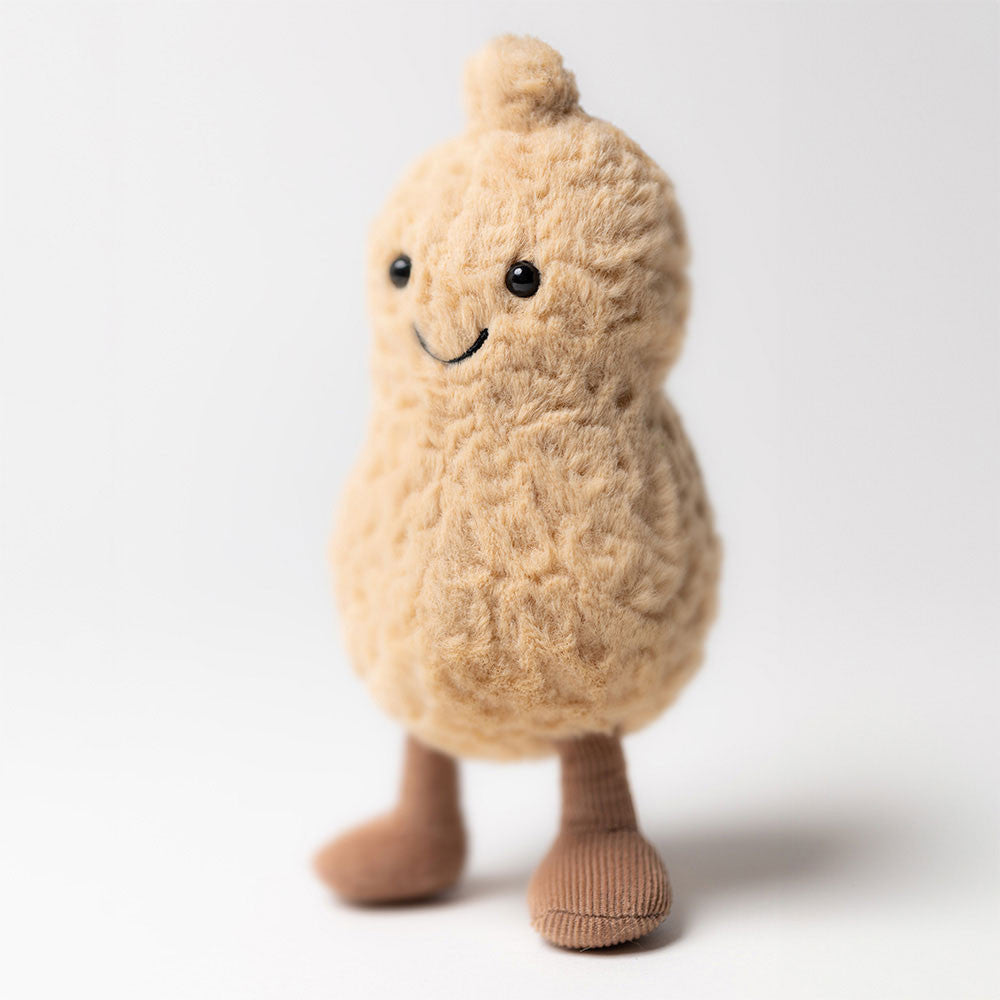 Plush toy shaped like a peanut with a smiling face on a white background