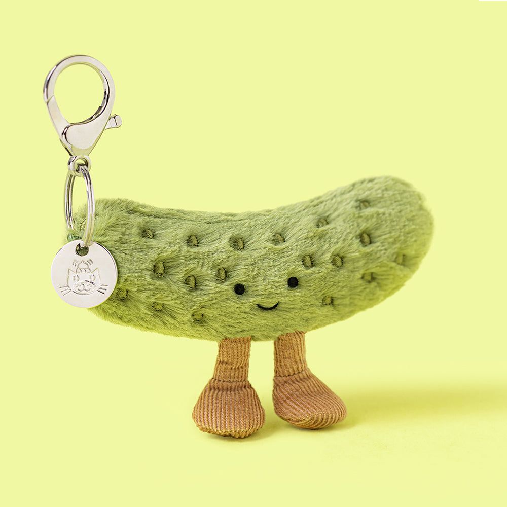 Plush pickle toy with a keychain on a yellow background