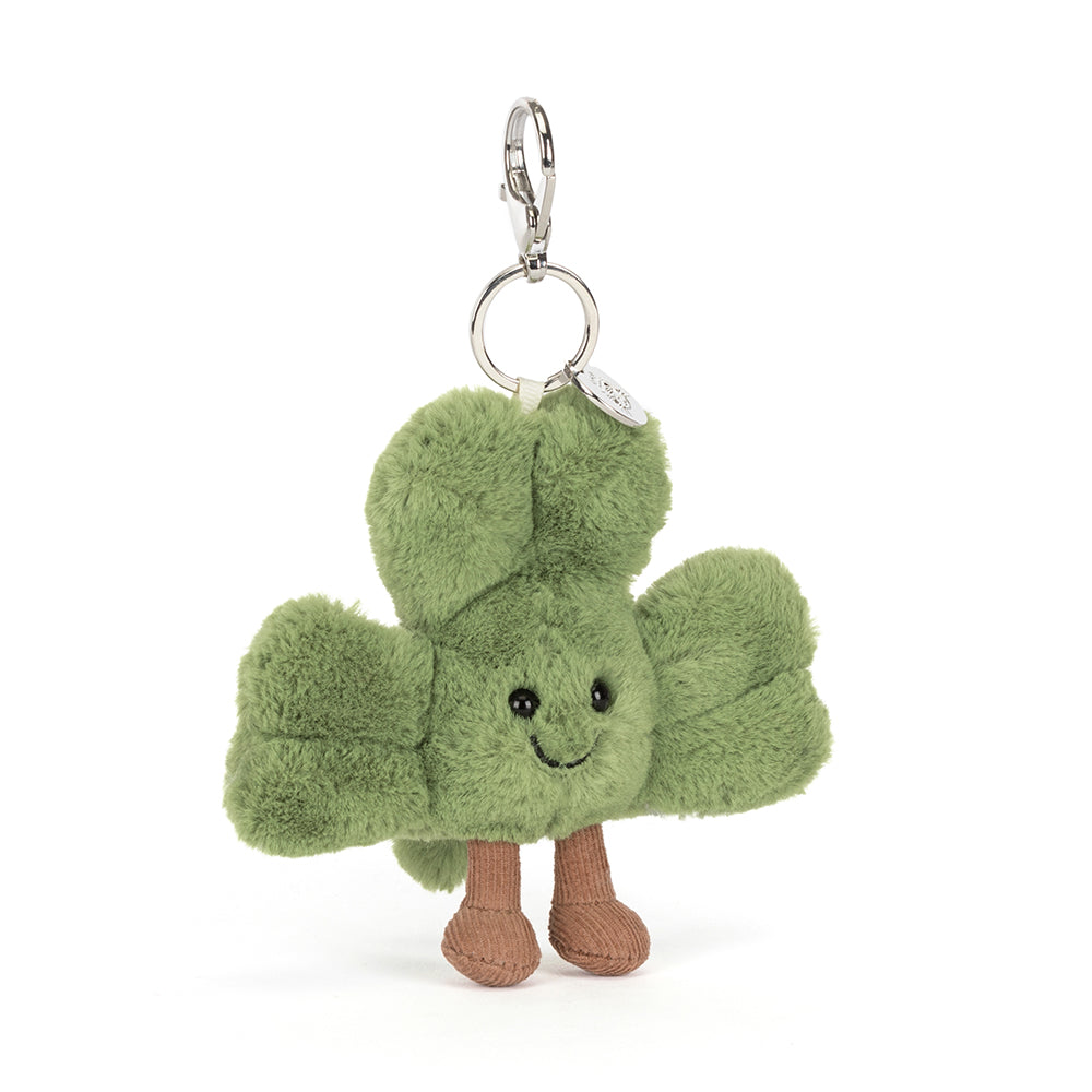 Plush keychain shaped like a green clover with a smiling face on a white background