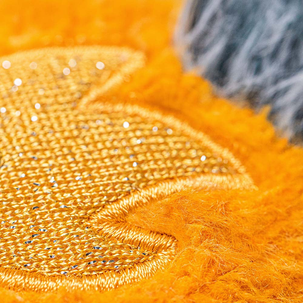 Close-up of orange fabric with textured pattern and metallic thread.