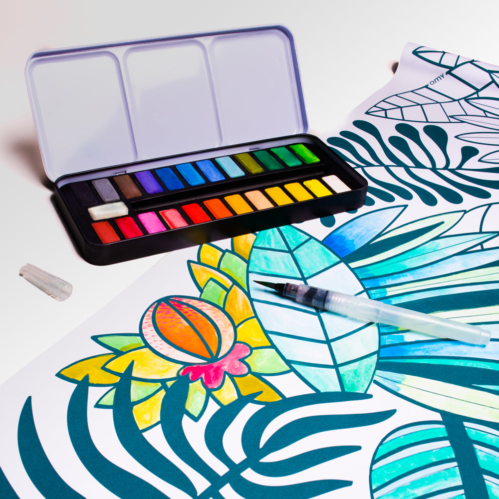 A portable watercolor paint palette with a clear plastic lid, containing 18 color pans in a spectrum of bright hues, and a small clear brush with a black tip resting inside the lid, shown on a solid white background.