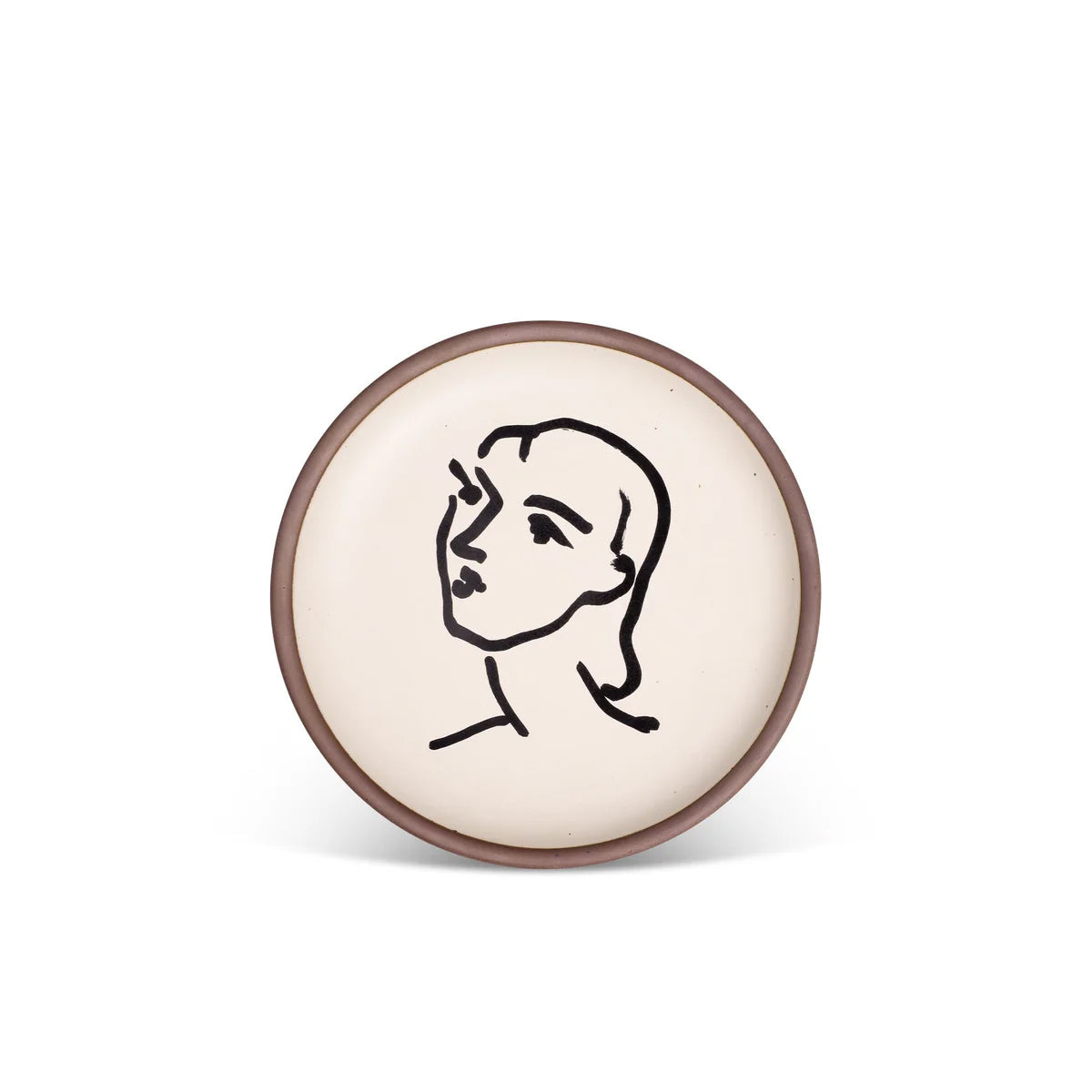 Round ceramic dish with a black line drawing of a face on a beige background