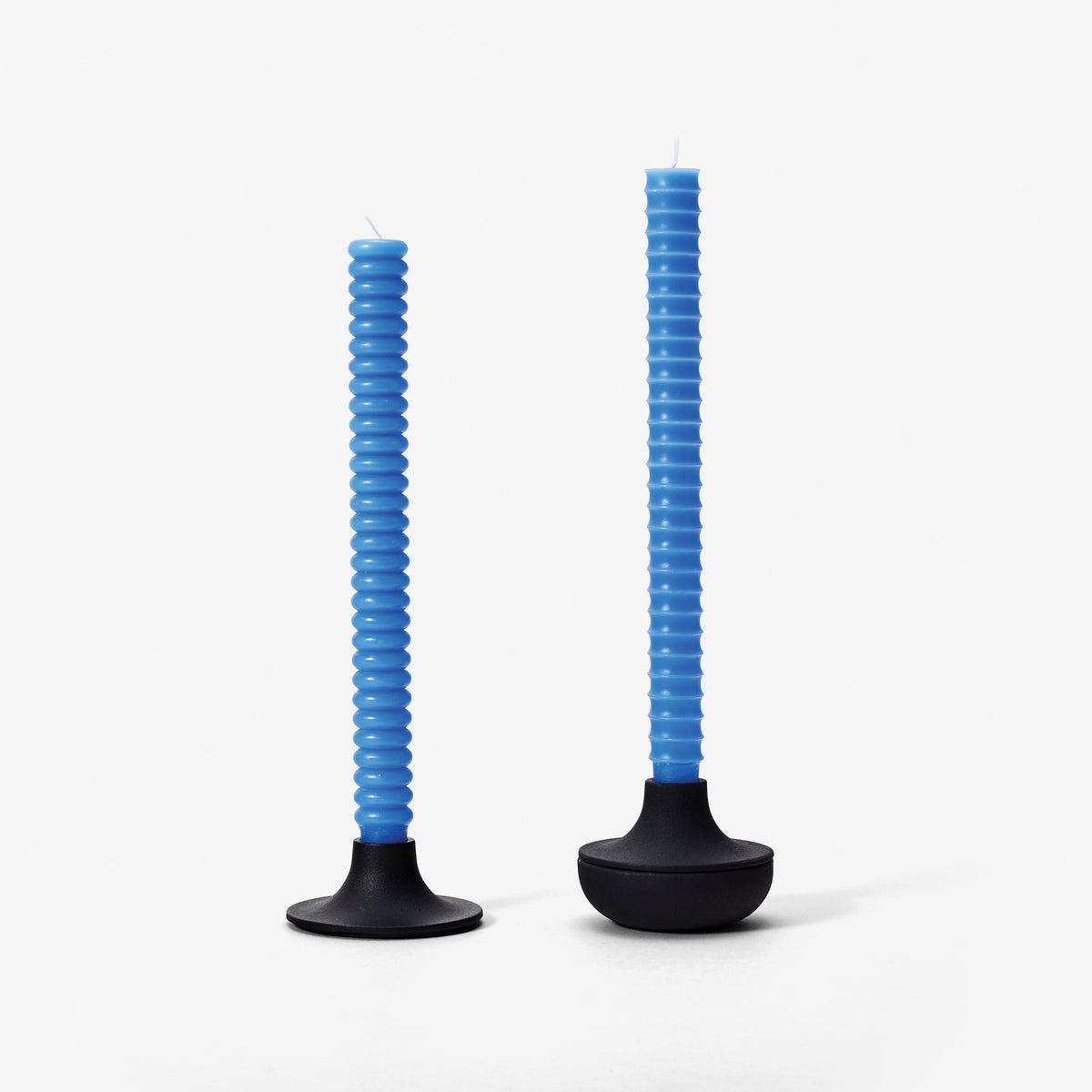 Two blue spiral candles with black bases on a white background