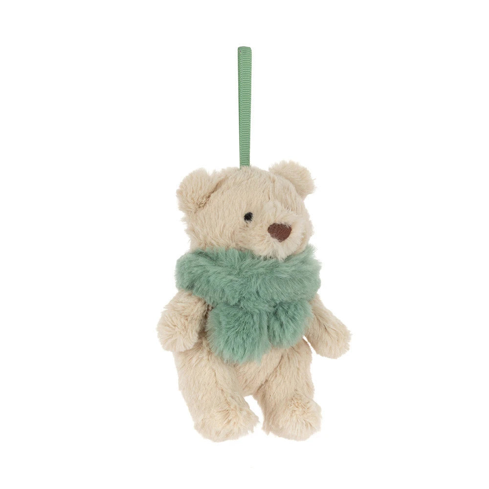 A small plush hanging bear ornament in biege and green white faux fur, suspended by a green ribbon on a plain white background.