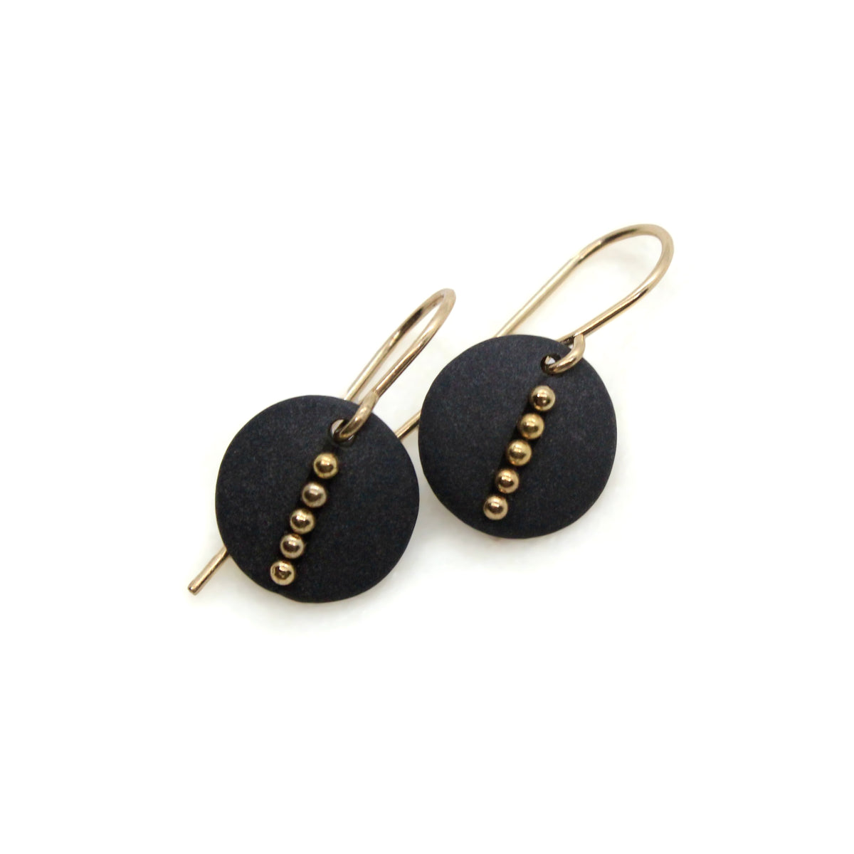 A pair of gold-tone drop earrings featuring matte black circular discs with a vertical line of small gold beads, shown on a plain white background.