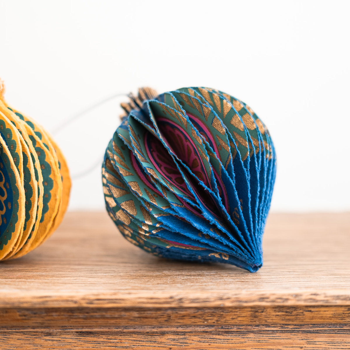 Decorative paper ornaments with intricate patterns on a wooden surface