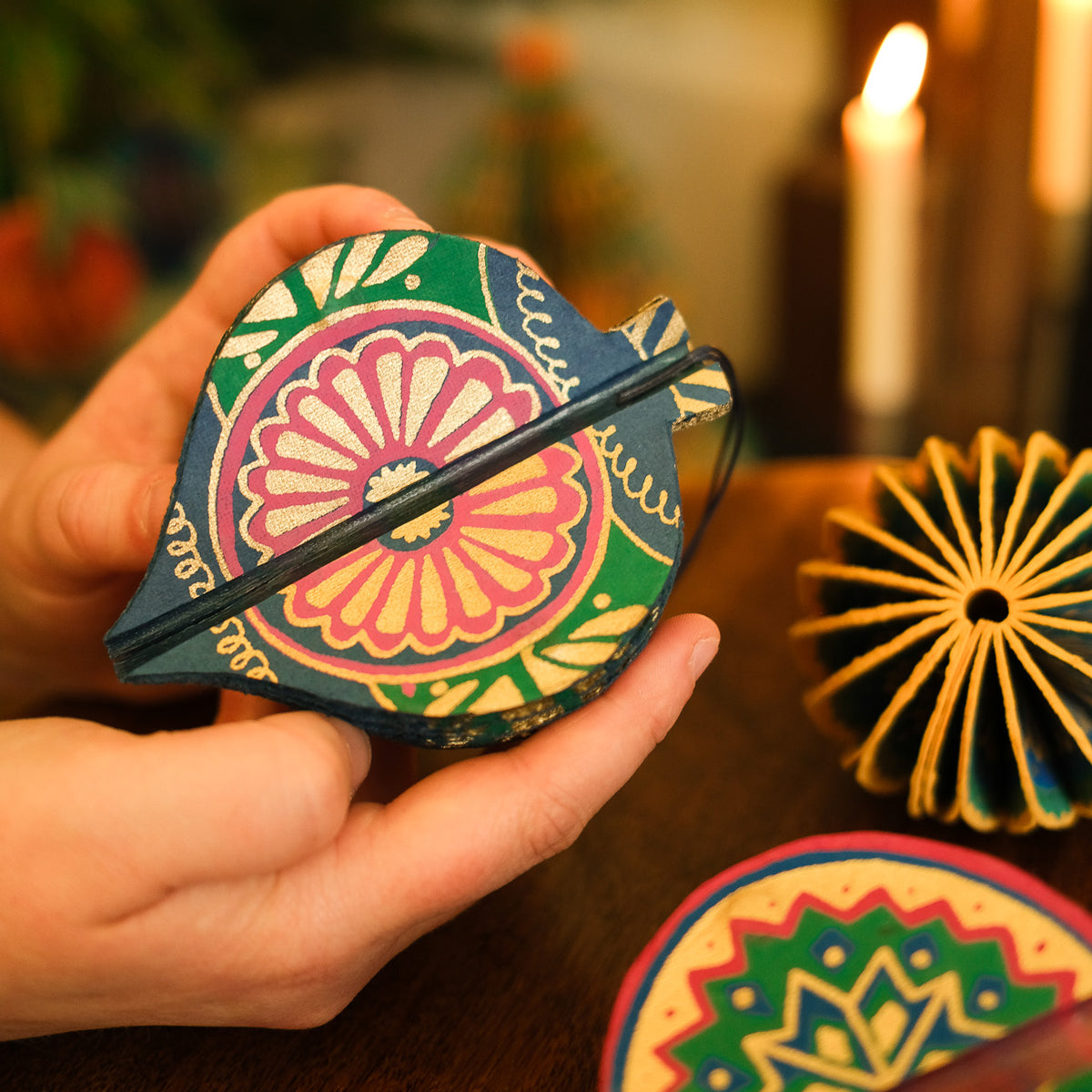 Decorative ornament with colorful patterns held by a hand