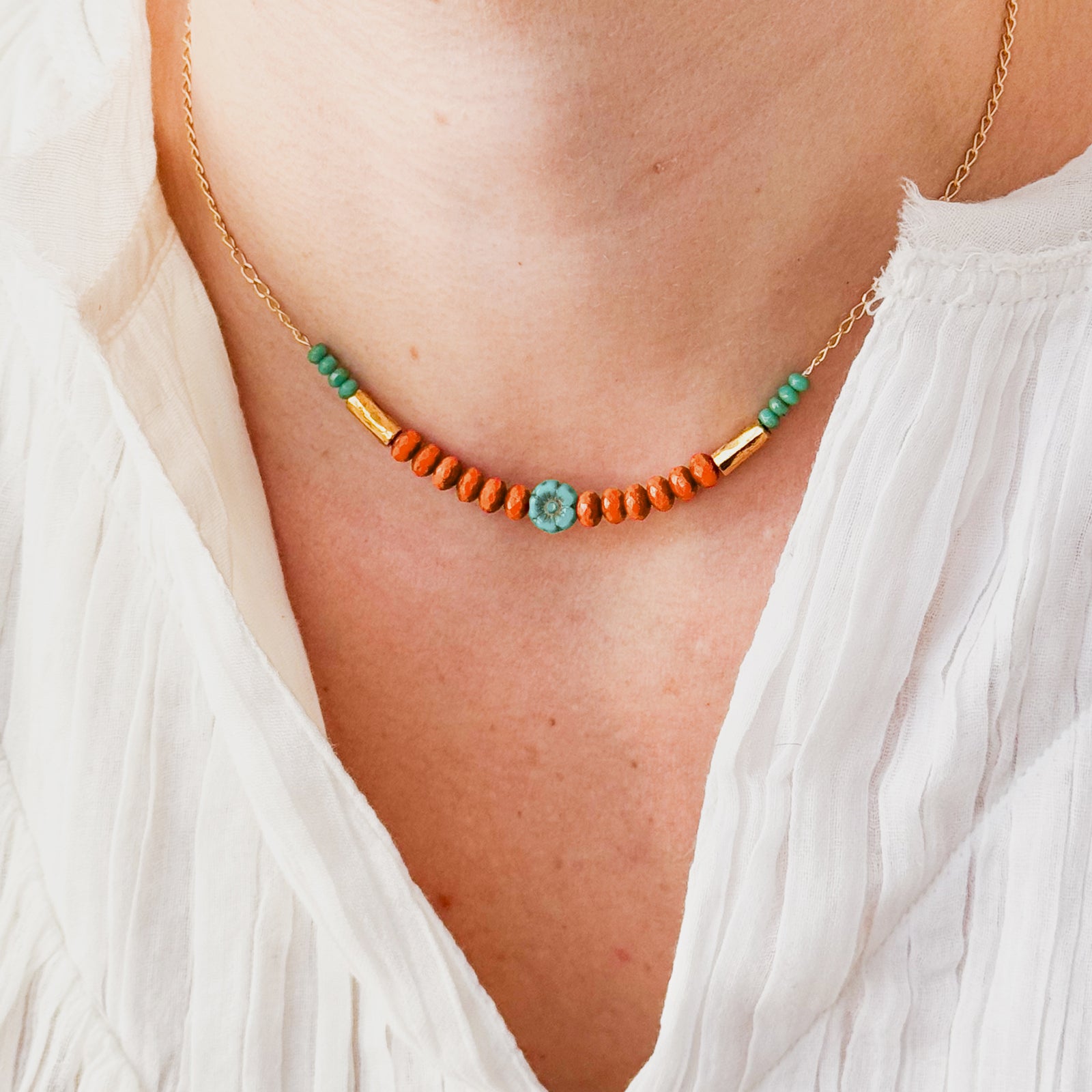 Necklace with orange and green beads on a white background