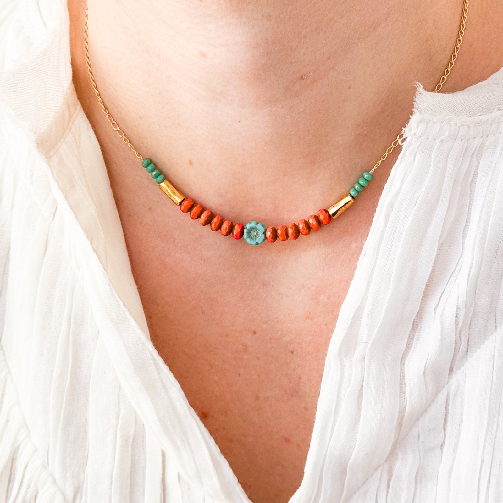 Necklace with orange and green beads on a white background