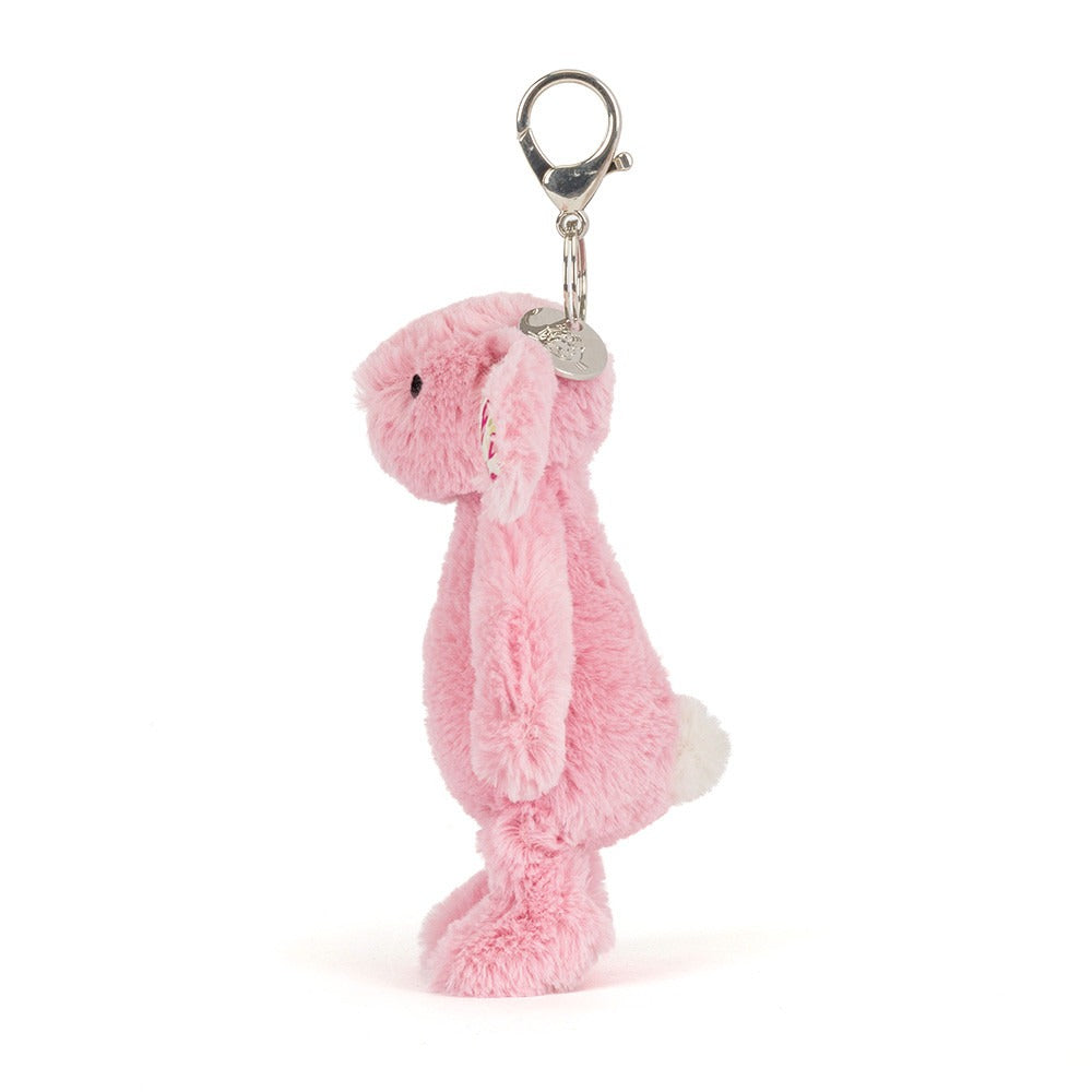Pink plush bunny keychain with floral patterns on a white background