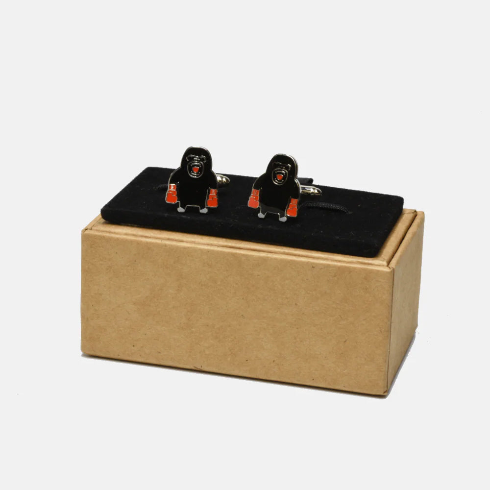Gorilla-shaped cufflinks on a white background.
