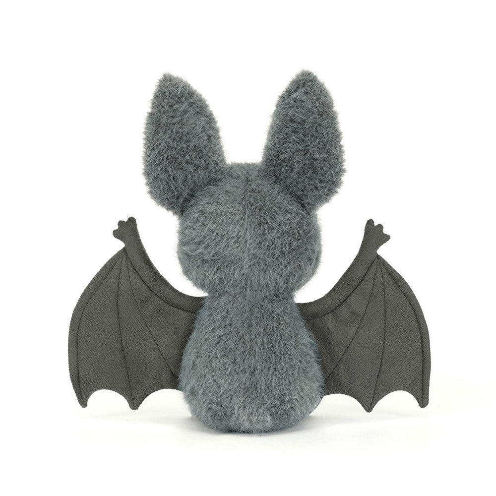 Plush toy bat with gray fur and black wings on a white background