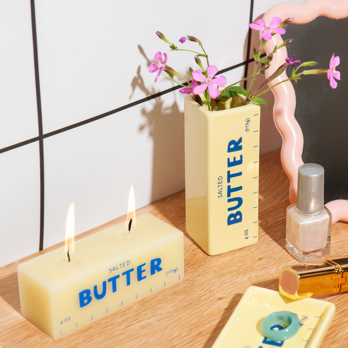Candle and decorative items with 'Butter' text on a wooden surface.
