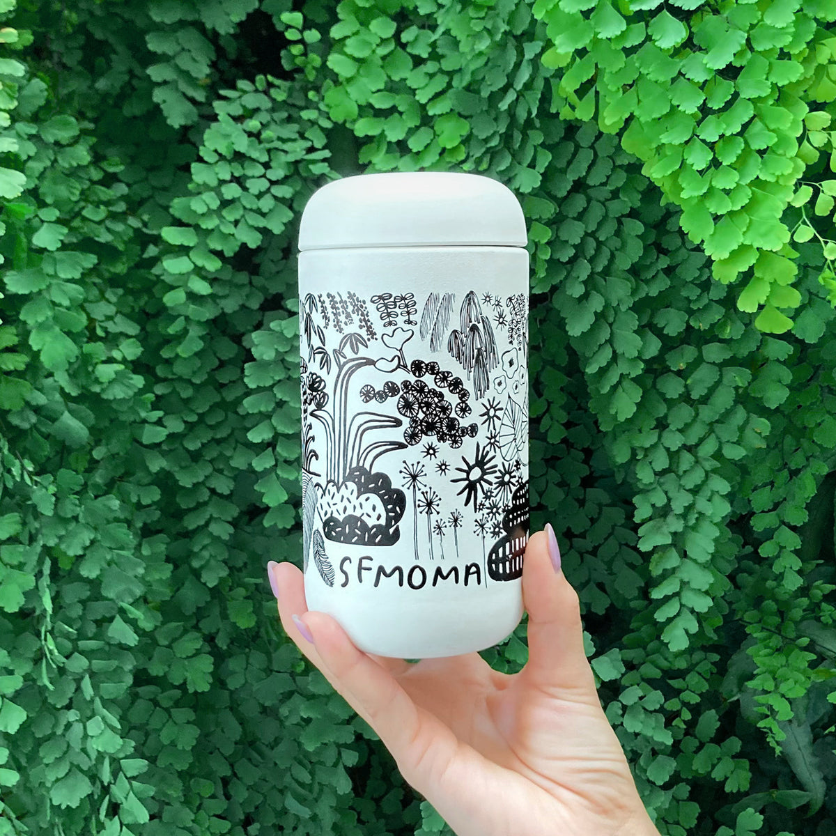 A hand holding a SFMOMA x Carissa Potter Move Mug.