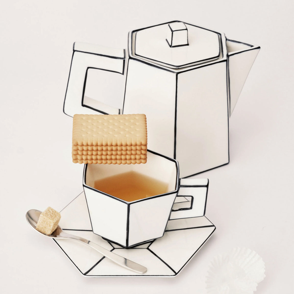 Geometric tea set with teapot, cup, and cookies on a white background