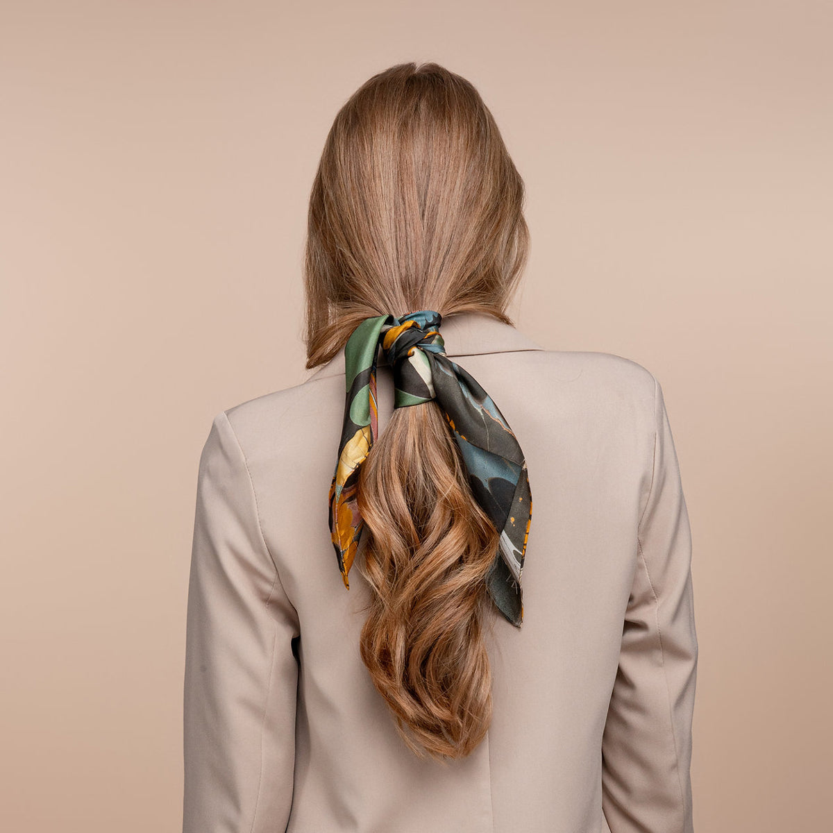 A square scarf featuring a marbled pattern with large green circles, black organic shapes, orange textured bands, and swirling blue, white, and pink details on a white background.