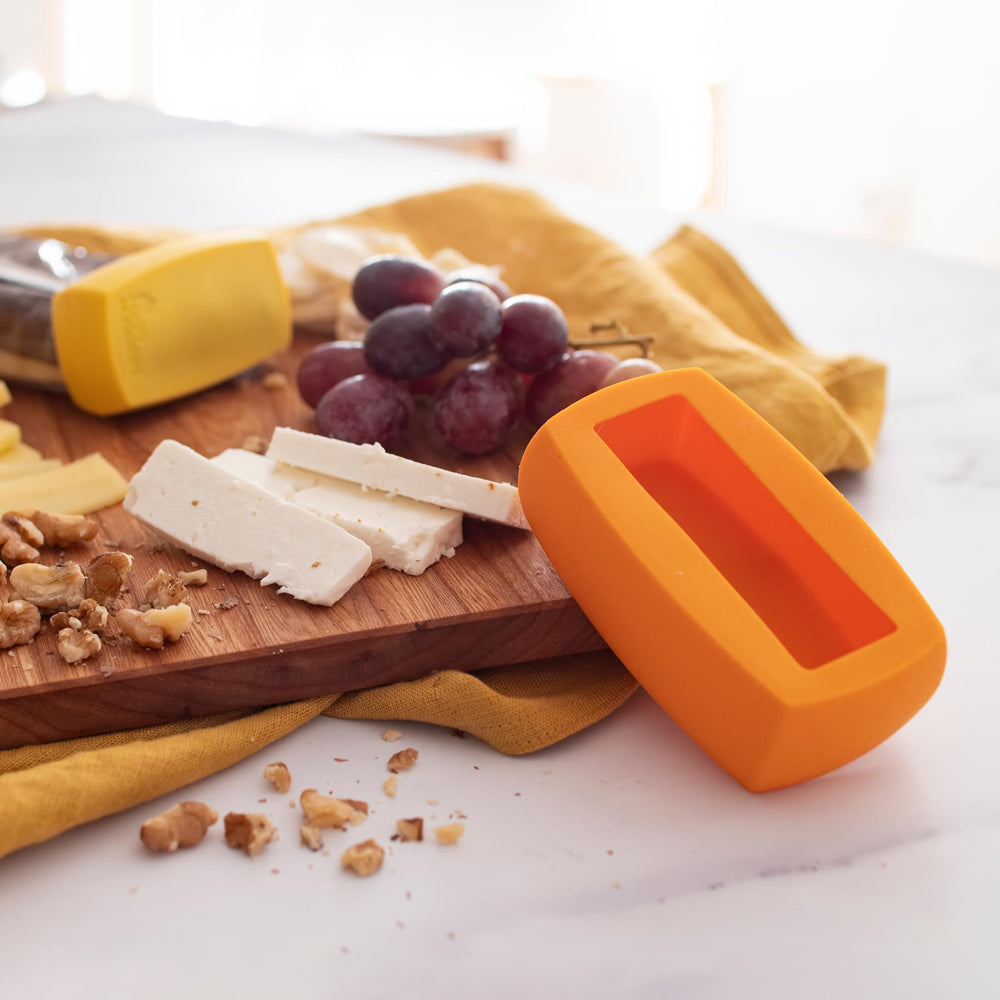 Two cheese huggers on a cheese board.