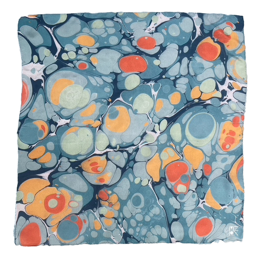 A square scarf featuring an abstract marbled pattern with swirling shades of slate blue, teal, orange, and cream, presented flat against a white background.