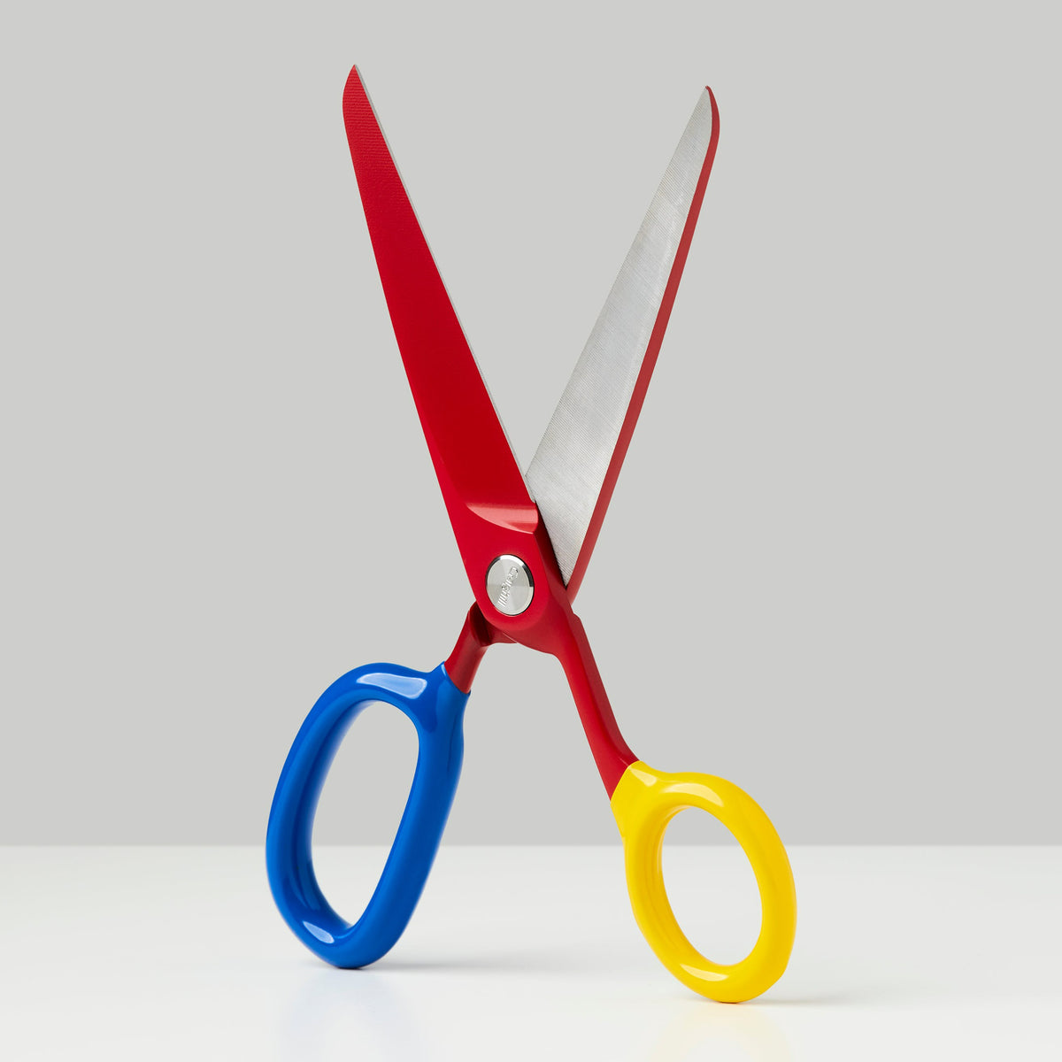 Colorful scissors with red, blue, and yellow handles on a white background
