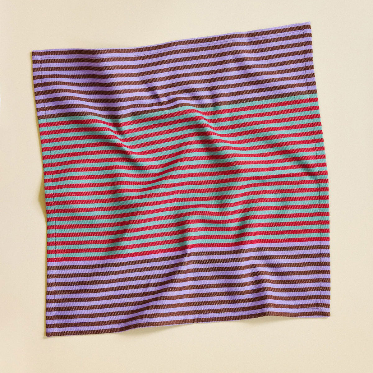 Striped fabric with purple, red, and green stripes on a beige background