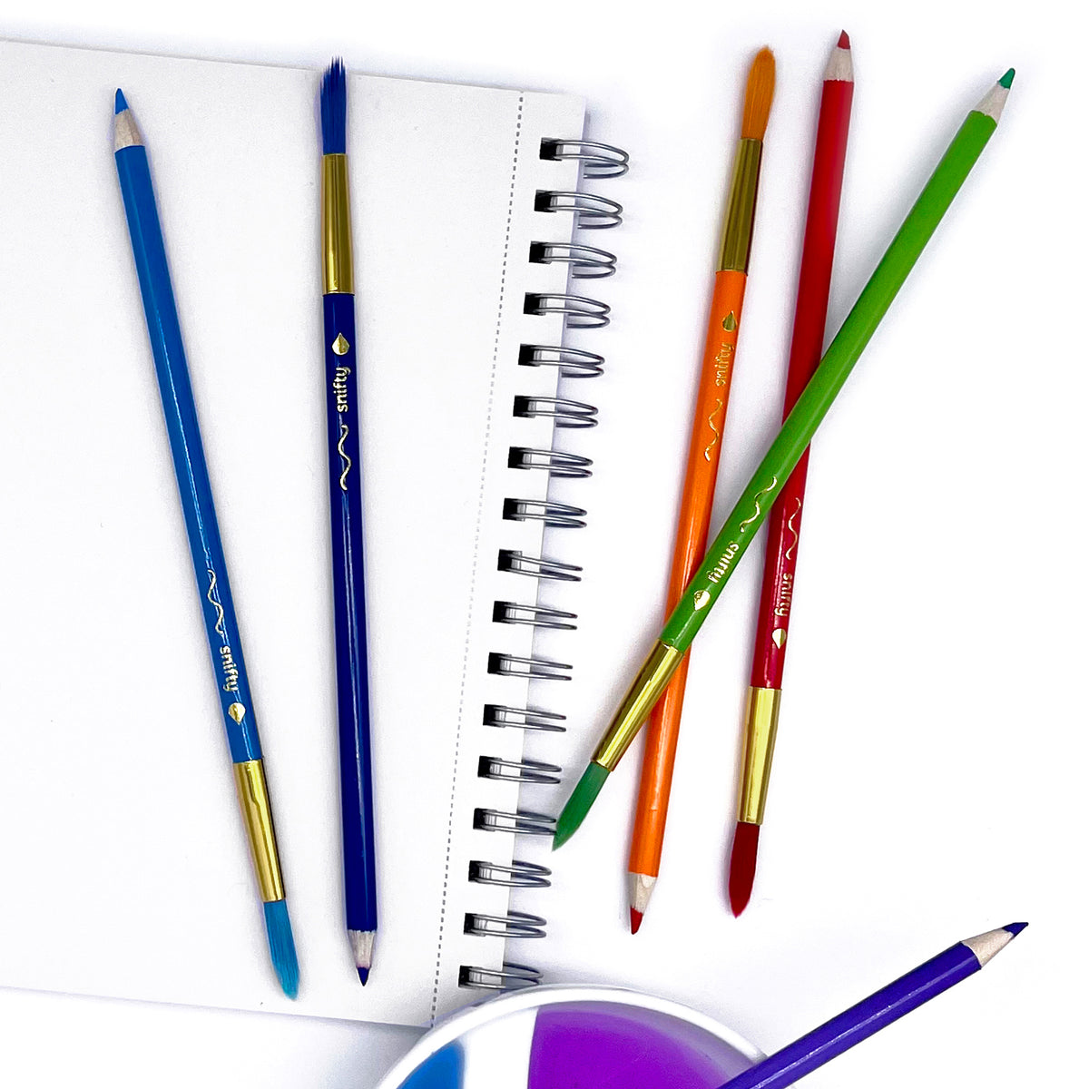 Colorful pencils on a white notebook