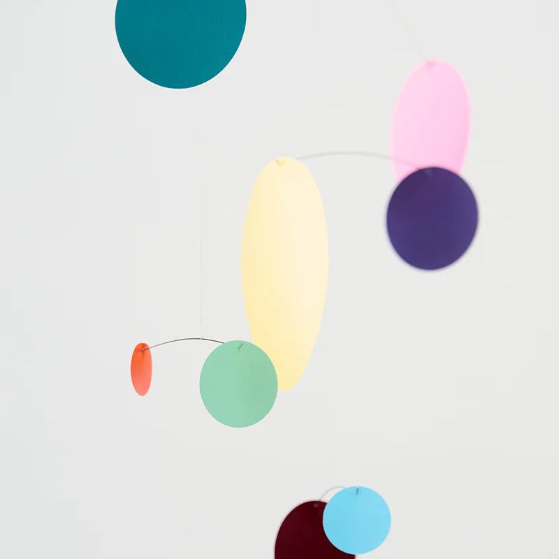 Colorful abstract mobile with hanging circles on a white background