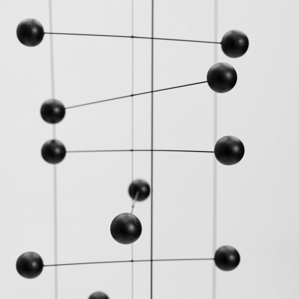 Black spherical objects on a white grid background