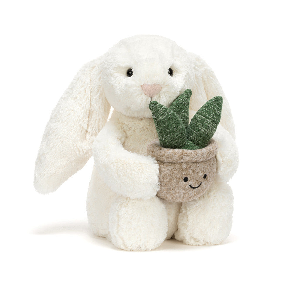 Plush bunny holding a potted plant on a white background