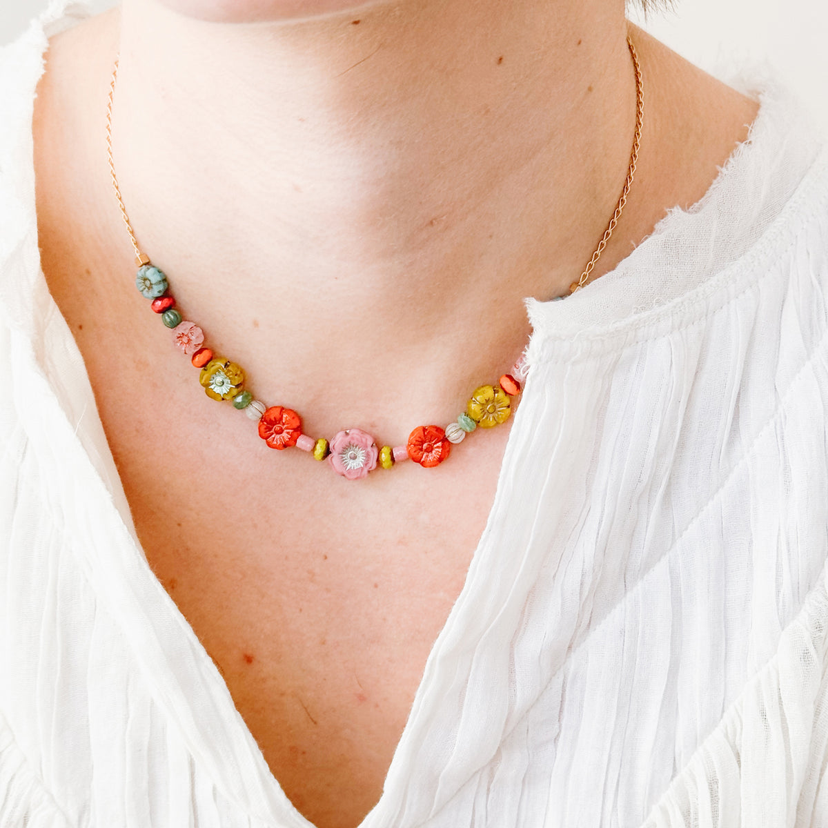 Colorful beaded necklace worn by a person with a white top
